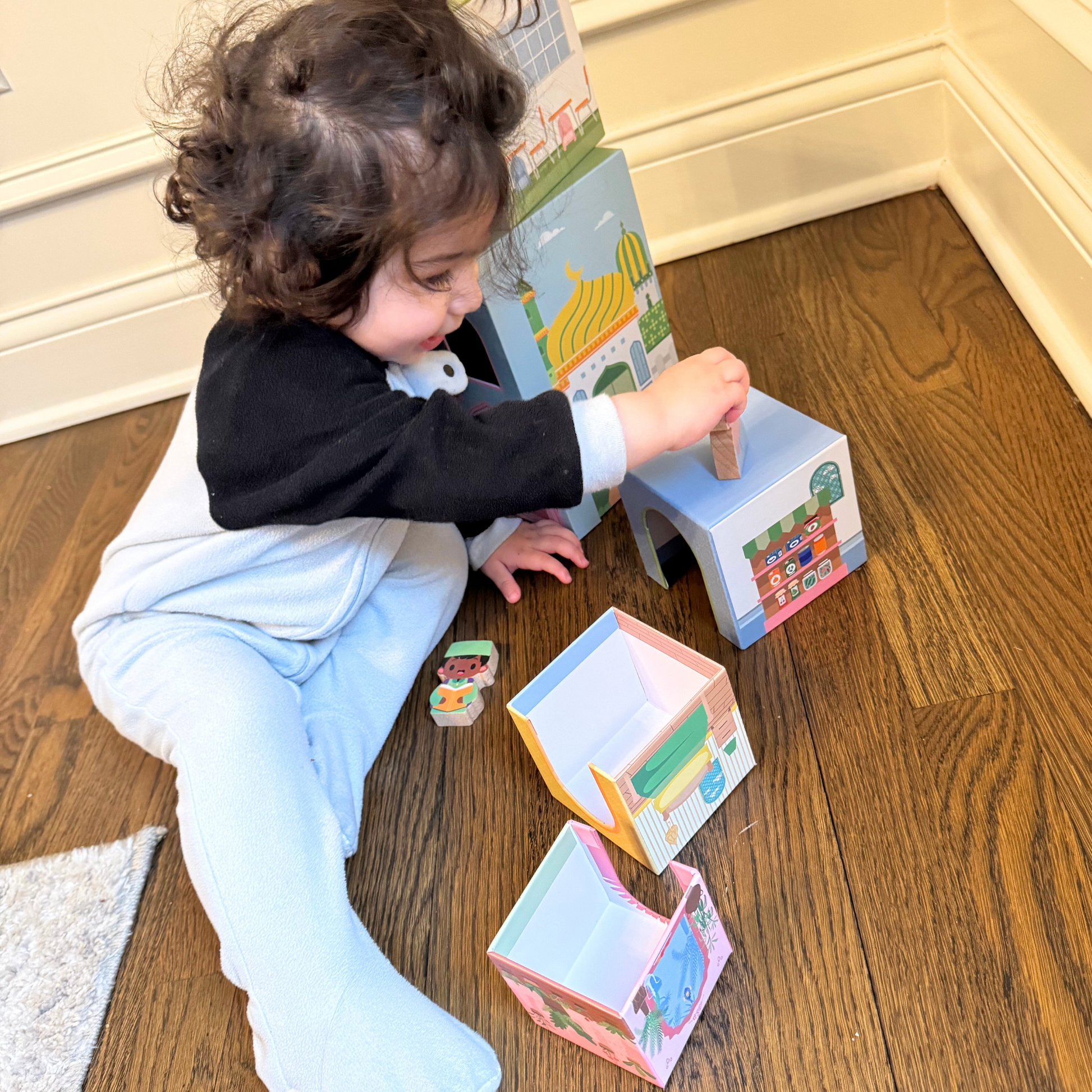 Toddler plays with Puzzle Planet stacking houses toy. Educational building blocks with masjid, school, home. Open-ended play.