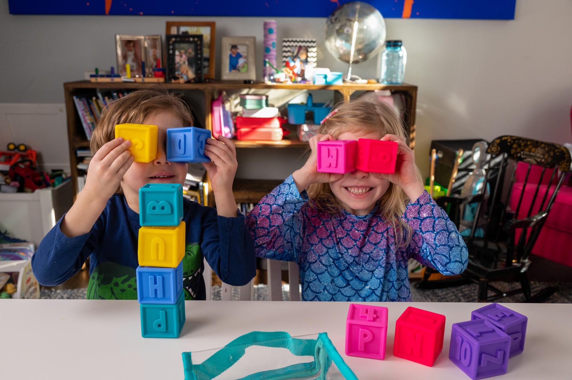 Kids playing with Squeeze & Stack alphabet blocks from Puzzle Planet. Educational toy for toddlers. 
