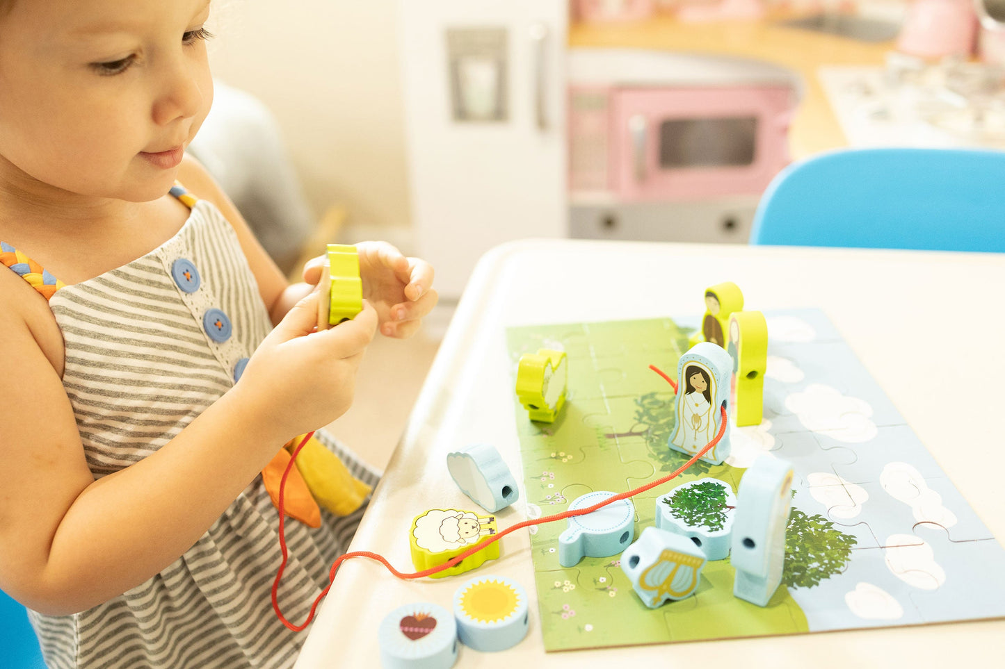 Child playing Our Lady of Fatima wooden lacing set. Religious toy for Catholic kids improving fine motor skills.