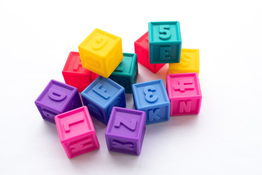Colorful baby blocks with letters and numbers. Squeeze and stack alphabet learning toys. Soft plastic educational cubes for toddlers.