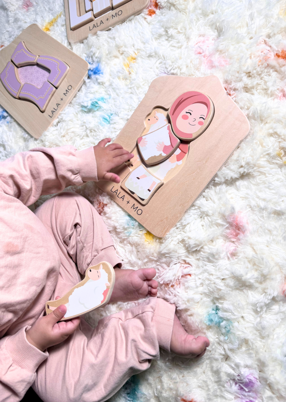 Child playing with Lala + Mo Islamic wooden puzzle: Muslim girl, sheep. Montessori learning toy.