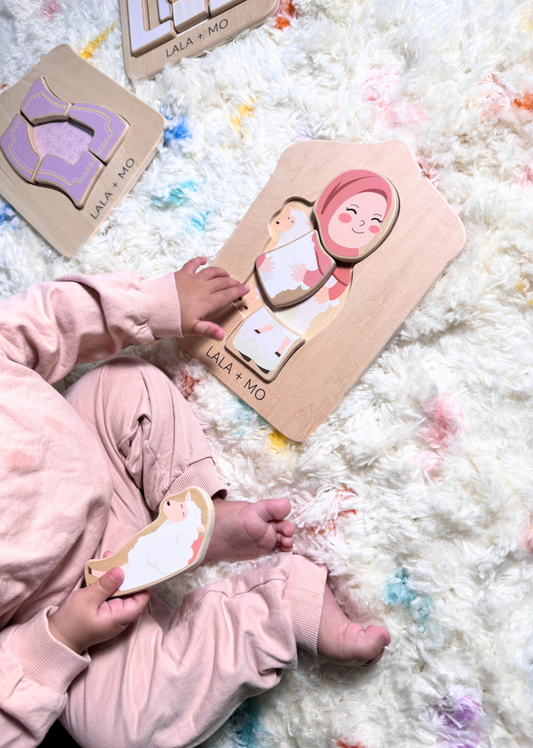 Child playing with Lala + Mo Islamic wooden puzzle: Muslim girl, sheep. Montessori learning toy.