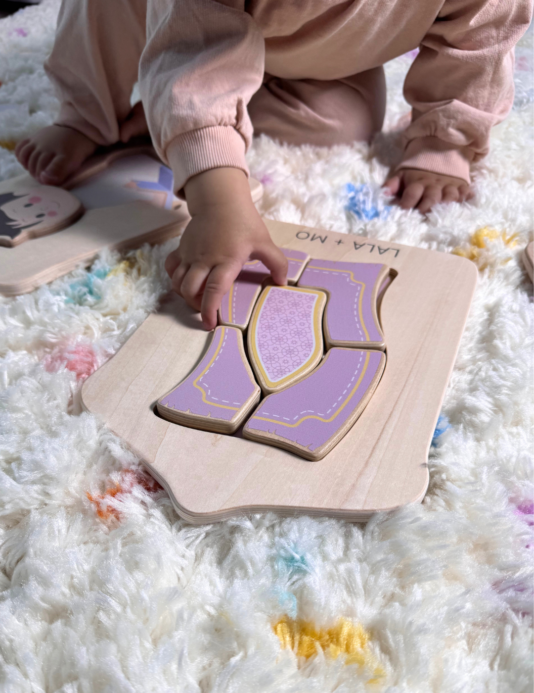 Child's hand playing with a wooden Islamic puzzle from Puzzle Planet. CHUNKY ISLAMIC BLOCK PUZZLES (SET OF FOUR).