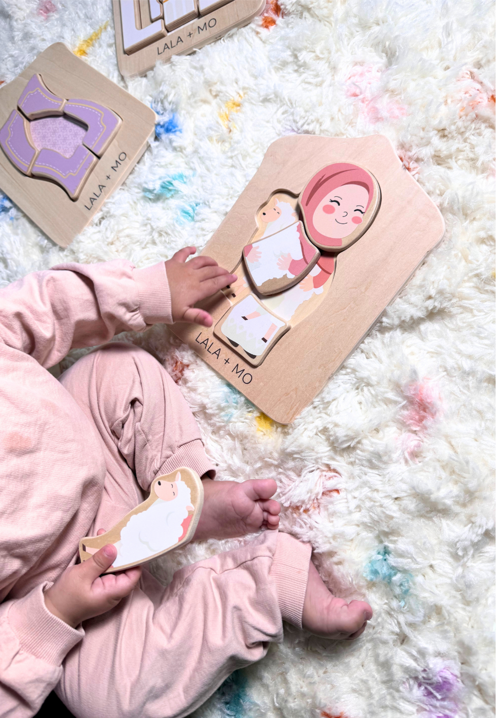 Child playing with Lala+Mo Islamic wooden puzzle from Puzzle Planet. Chunky blocks, educational toy, cognitive development.